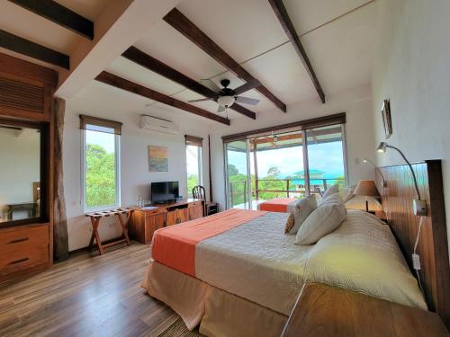 sypialnia z dużym łóżkiem i wentylatorem sufitowym w obiekcie Semilla Verde Boutique Hotel w mieście Puerto Ayora