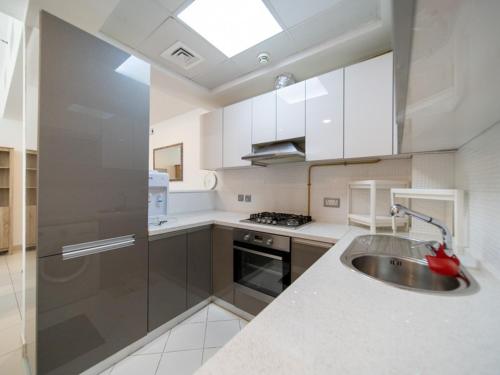 a kitchen with a sink and a stove at DUBAI - Glitz 3 Residences - MAJESTIC Luxe Holiday Home - 2BR - Sleep 4 - FOR FAMILIES & COUPLES STAYS ONLY in Dubai