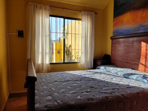 1 dormitorio con cama y ventana en Casa Amarrilla en San Clemente del Tuyú