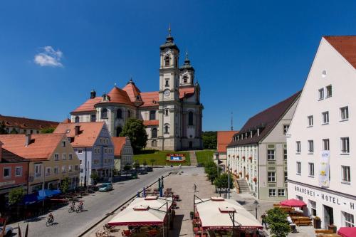a city with a clock tower and a street with buildings at FeWo HoLiDay ApartMENT Allgäu in Ottobeuren