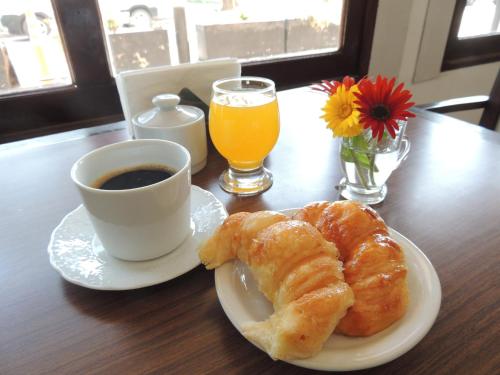 a table with a cup of coffee and a plate of pastries at Park View Hotel & Residences in Campana