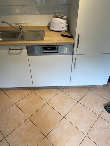 a kitchen with white cabinets and a sink at Gästehaus Bönebüttel-nahe Neumünster Netflix in Bönebüttel