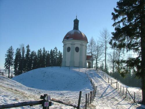 a building on top of a snow covered hill at FeWo HoLiDay ApartMENT Allgäu in Ottobeuren