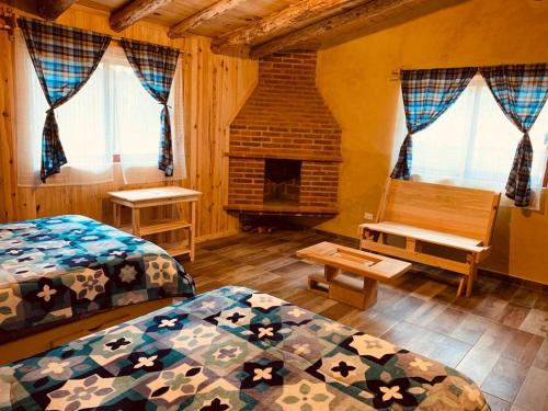 a bedroom with two beds and a fireplace at Cabañas Zacatlan Zacapa in San José Ayotla