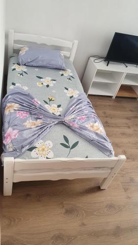 a bed with a floral comforter in a room at ARBI GUEST House in Kukës