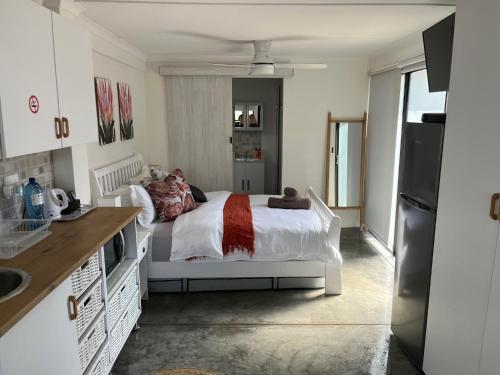 a bedroom with a white bed in a kitchen at Lala Pansie in Stilbaai