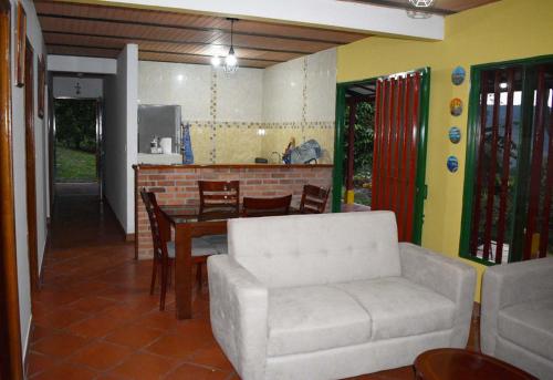 a living room with a table and a white couch at Casa Campestre Villa del Lago in Guaduas