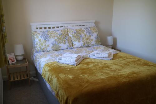 1 dormitorio con 1 cama con 2 toallas en Littledown, en Bournemouth