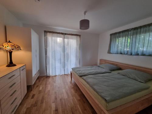 1 Schlafzimmer mit 2 Betten, einer Lampe und einem Fenster in der Unterkunft Gemütliche Premium Ferienwohnung mit Terrasse nähe S-Bahn in Burgthann