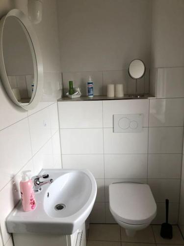 a bathroom with a sink and a toilet and a mirror at Gästehaus Bönebüttel-nahe Neumünster Netflix in Bönebüttel