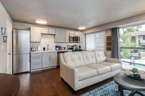 a living room with a white couch and a kitchen at HOLLY FIRST FLOOR 2 King Beds in Kansas City