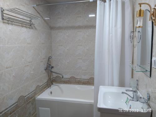 a bathroom with a tub and a toilet and a sink at SAID-MAXSUM in Khiva