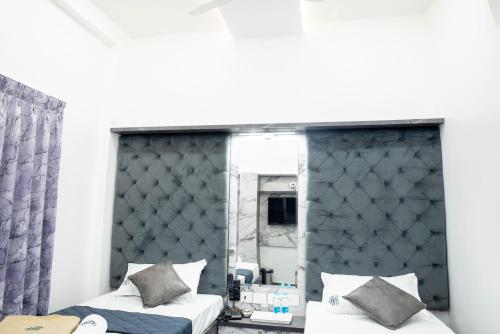 1 dormitorio con 2 camas y espejo en JSM Residency, en Chennai