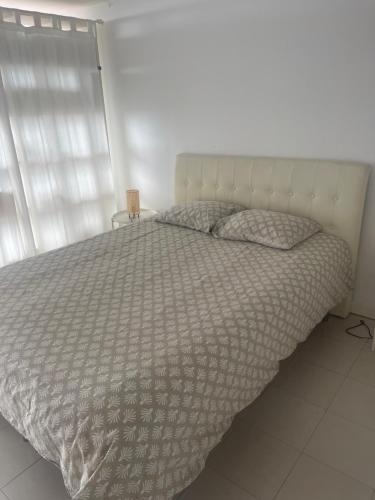 ein Schlafzimmer mit einem Bett mit einer weißen Tagesdecke in der Unterkunft São João Beach Lounge in Costa da Caparica