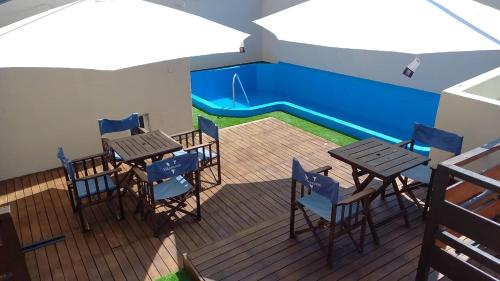 eine Terrasse mit Tischen und Stühlen sowie einen Pool in der Unterkunft Hotel Monterrey in Termas de Río Hondo