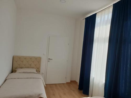 a bedroom with a bed and a blue curtain at Stan na dan in Batuša