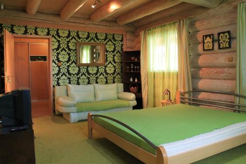 a bedroom with a bed and a couch and a television at Liptovsky Zrub in Gôtovany