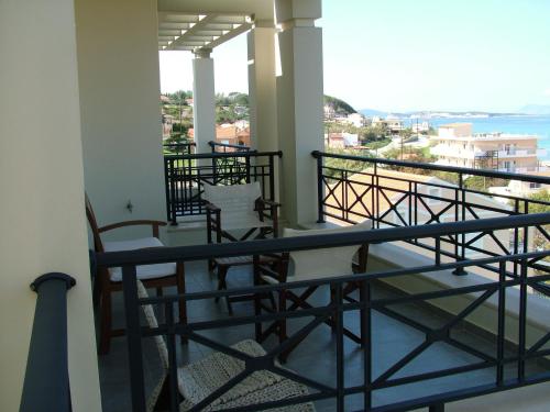 a balcony with chairs and a view of the ocean at Sugar and Almond in Agios Stefanos