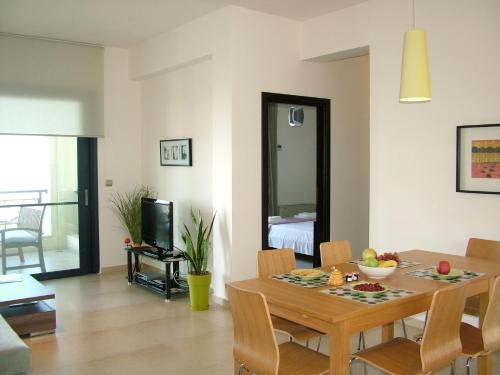 a dining room and living room with a table and chairs at Sugar and Almond in Agios Stefanos