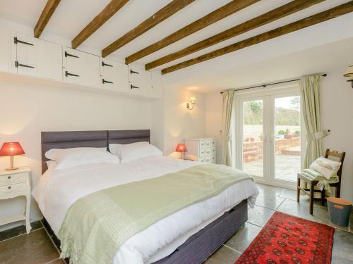 Un dormitorio con una cama grande y una ventana en Eton Cottage en Farnham