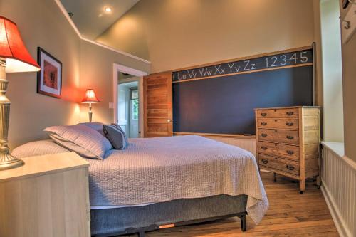 a bedroom with a large bed and a dresser at Cozy Wrightsville Cottage with Private Hot Tub! in Wrightsville