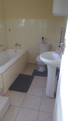 uma casa de banho com um WC, uma banheira e um lavatório. em The glory house em Alberton