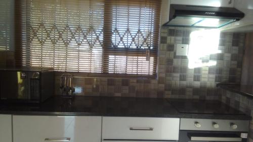 a kitchen with a black counter top and a window at The glory house in Alberton
