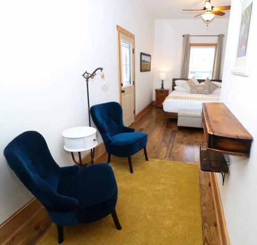 a bedroom with a bed and two chairs and a table at Sweetwater Branch Inn in Gainesville