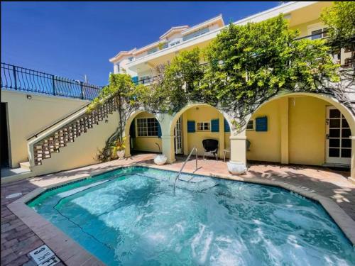 a swimming pool in front of a house at Courtyard Villa Hotel in Fort Lauderdale