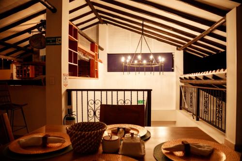 a dining room with a table and a chandelier at Terra Inn Hotel Boutique in Guaduas