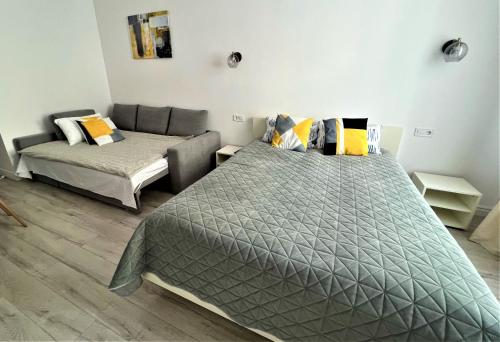 a bedroom with two beds and a couch at Iris apartment on Popovich in Lviv