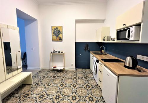 a kitchen with blue and white walls and a tile floor at Iris apartment on Popovich in Lviv