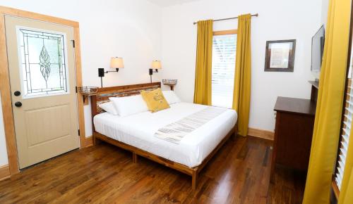 a bedroom with a white bed and a window at Sweetwater Branch Inn in Gainesville