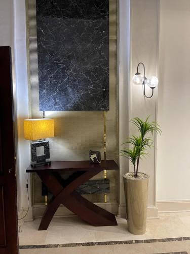 a desk with a lamp and a plant in a room at Awesome Villa on a hill Families only in Cairo