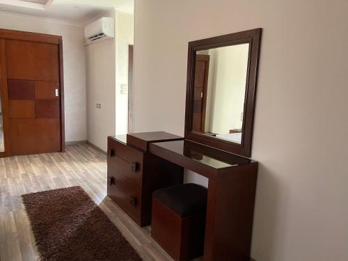 a dresser with a mirror and a chair in a room at Awesome Villa on a hill Families only in Cairo