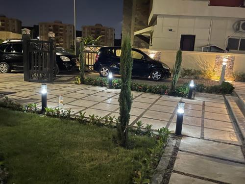 a sidewalk with lights in a parking lot at night at Awesome Villa on a hill Families only in Cairo