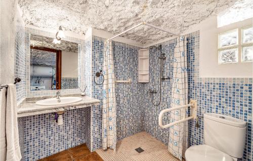 a blue tiled bathroom with a toilet and a sink at Stunning Home In Cuevas Del Campo With House A Mountain View in Cuevas del Campo