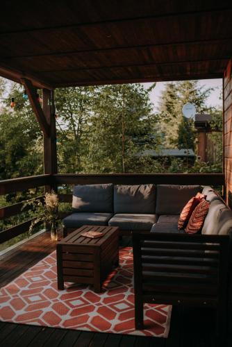 a couch on a porch with a coffee table at Biała Dom z widokiem in Biala