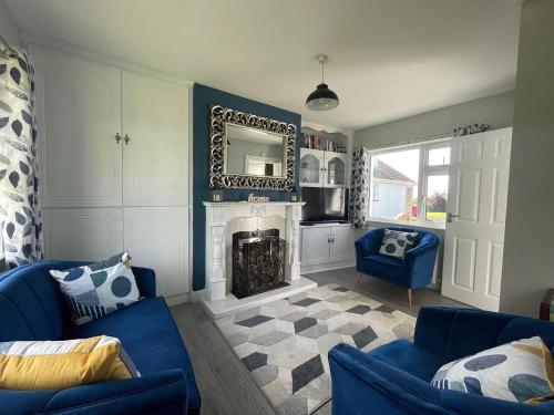 a living room with a blue couch and a fireplace at Fernfield Cottage in Donegal