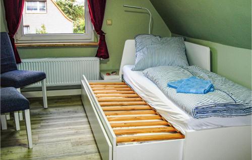 ein kleines Bett in einem Zimmer mit Fenster in der Unterkunft Amazing Home In Neubrandenburg With Wifi And 3 Bedrooms in Neubrandenburg