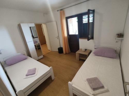 ein kleines Zimmer mit 2 Betten und einem Spiegel in der Unterkunft Apartment Nakić in Vrpolje