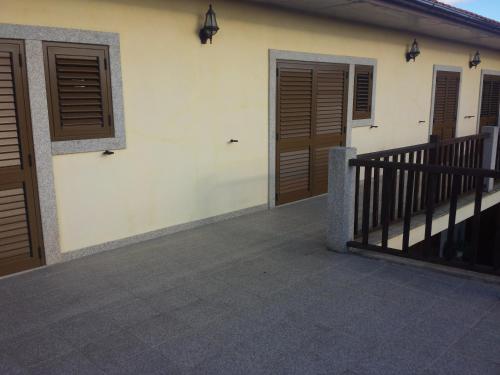 a house with wooden doors and a balcony at Moleiro de Bacal in Baçal