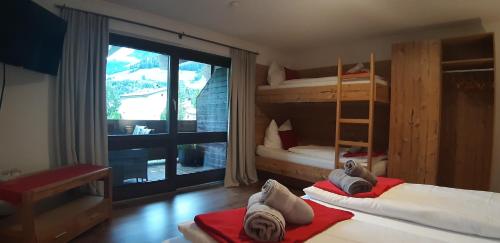 a bedroom with two bunk beds and a balcony at Gästehaus Huber in Mittersill