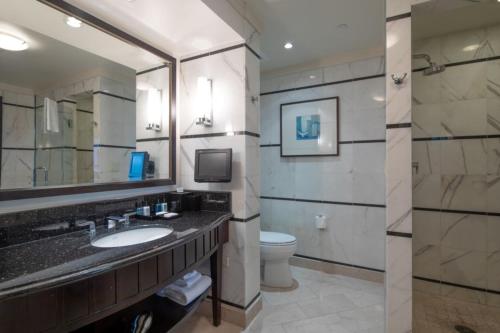 a bathroom with a sink and a toilet and a mirror at One-Bedroom Apartment in Miami Beach