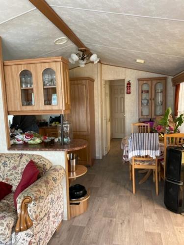 uma sala de estar com um sofá e uma mesa em Mobilhome em Noyelles-sur-Mer