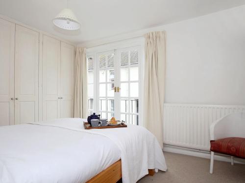 a bedroom with a white bed and a window at North Laine Cottage in Brighton & Hove