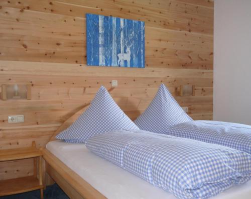 twee bedden in een kamer met een houten muur bij Alte Schmiede in Balderschwang