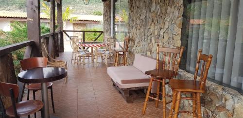 a porch with chairs and tables and a table with a tree at Gojim Casa Rural in Armamar