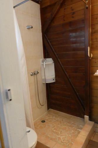 a bathroom with a toilet and a wooden door at IWANA en Guadeloupe in Bouillante