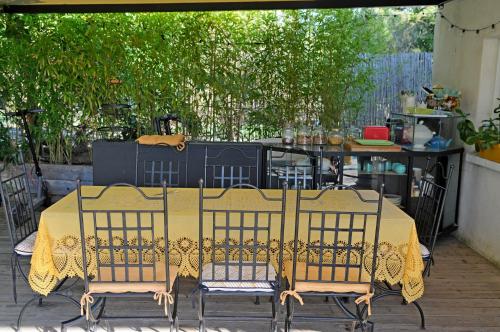 a table with a yellow table cloth on a patio at B&B La Terre Brûlée in Aigues-Mortes